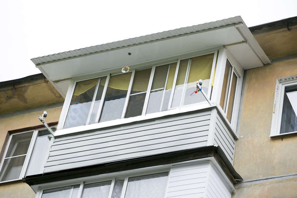 Остекление балкона (алюминиевая рама) и монтаж капитальной крыши с увеличением козырька на 70 см. 